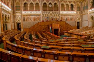 Rows of wooden benches inside the ornate parliamentary chamber in Budapest, Hungary.